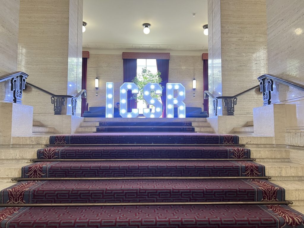 ICSR letters in physical form, lit up with lights, at the top of stairs at the venue.